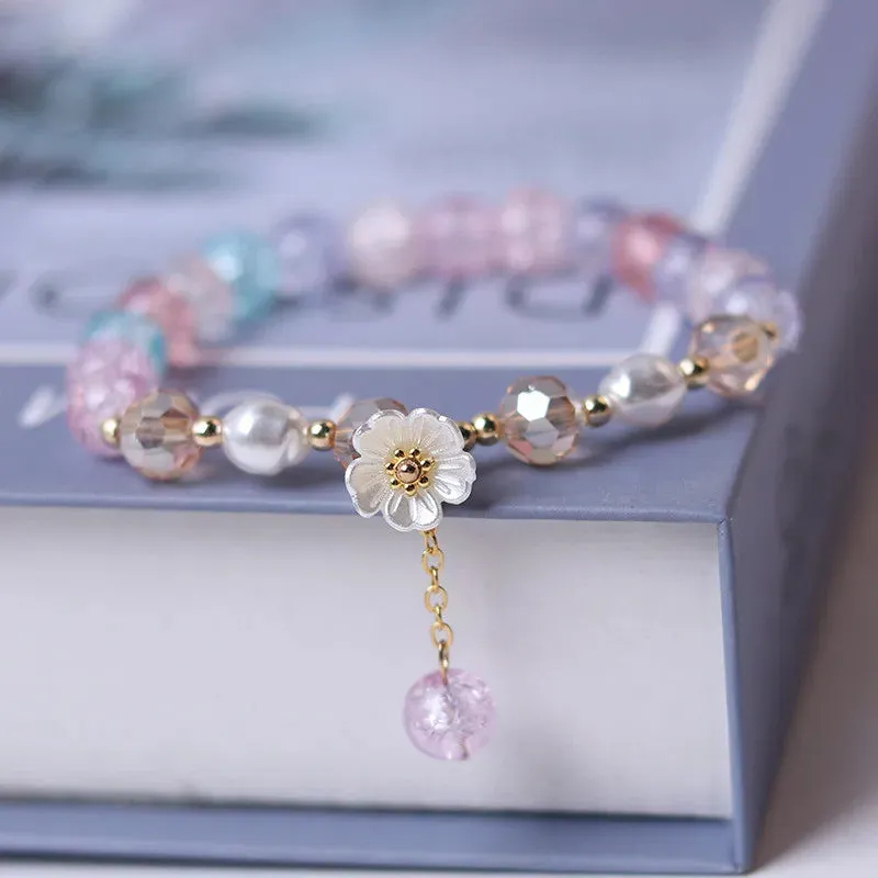 Bracelet ajustable avec fleur blanche et perles de cristal mauves, vertes ou blanches (5 coloris)